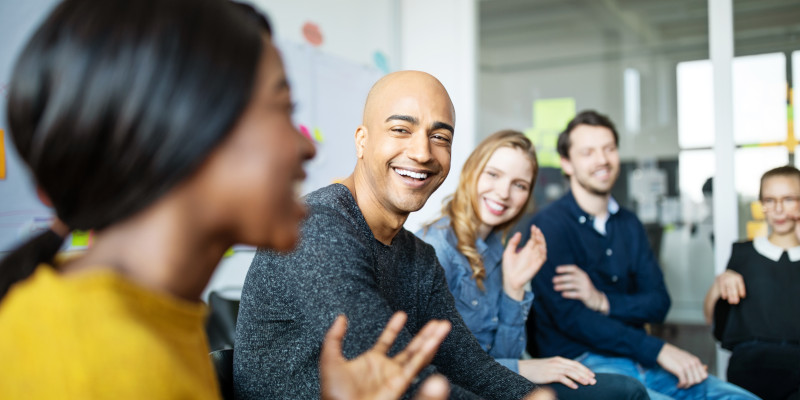 Image shows a group of colleagues engaged in conversation