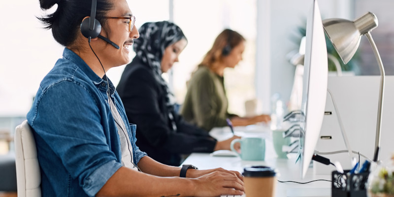 Customer service representatives use computers at a desk