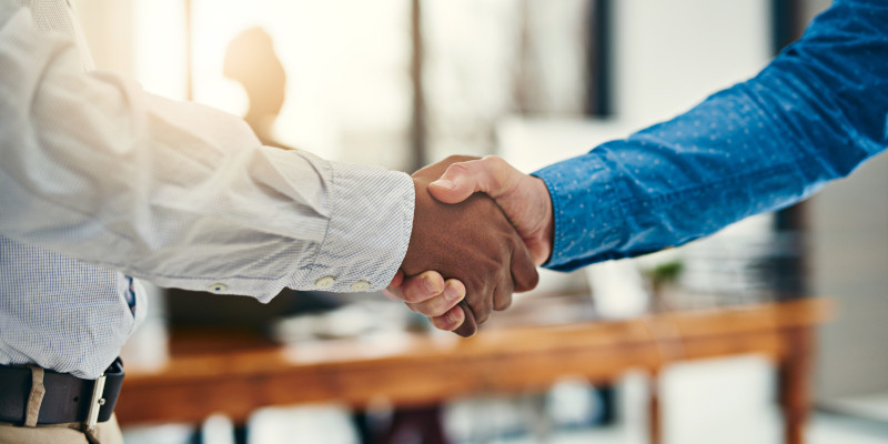 Image shows two people shaking hands.